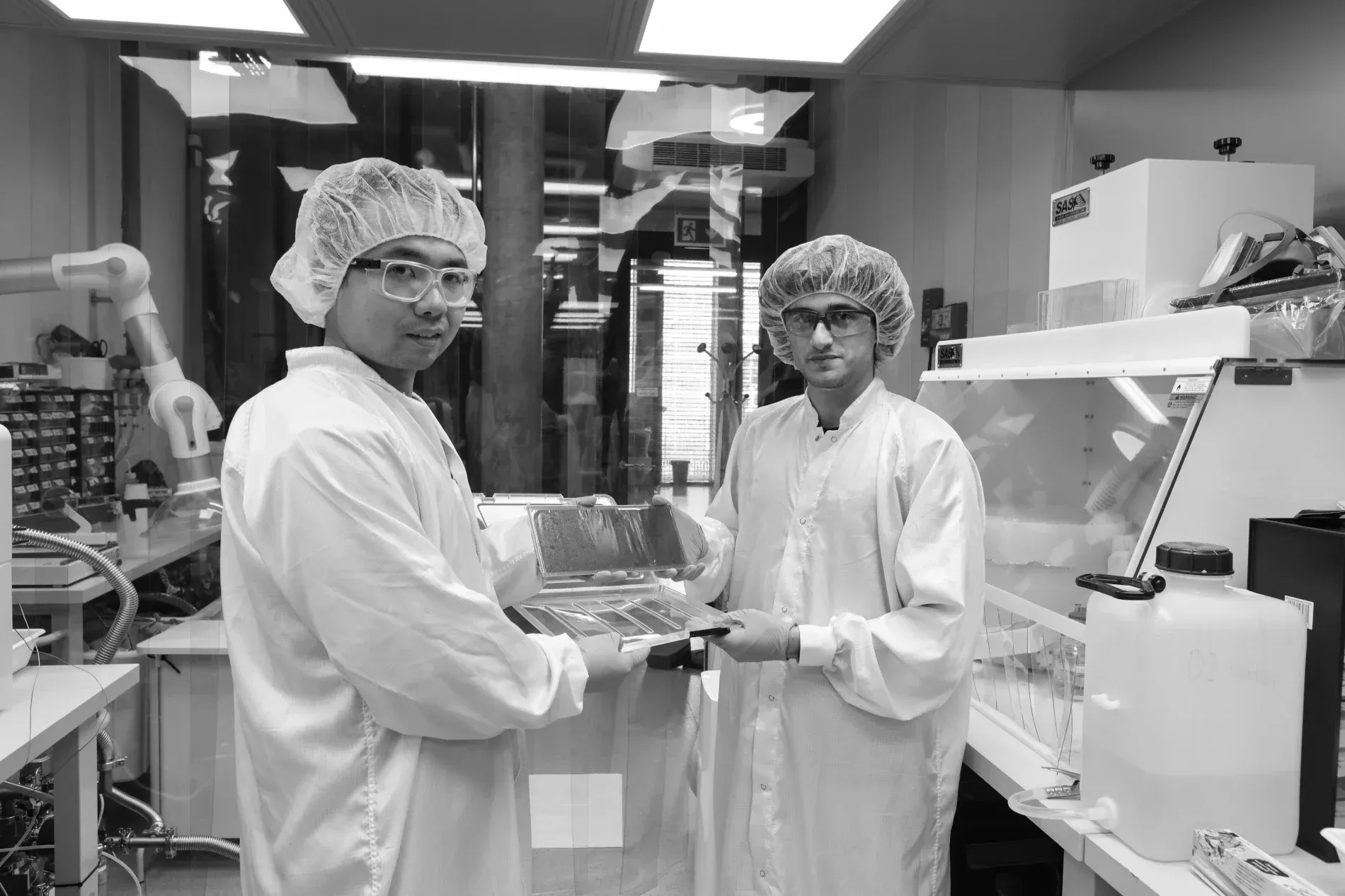 Students in clean-room suits handling membrane samples